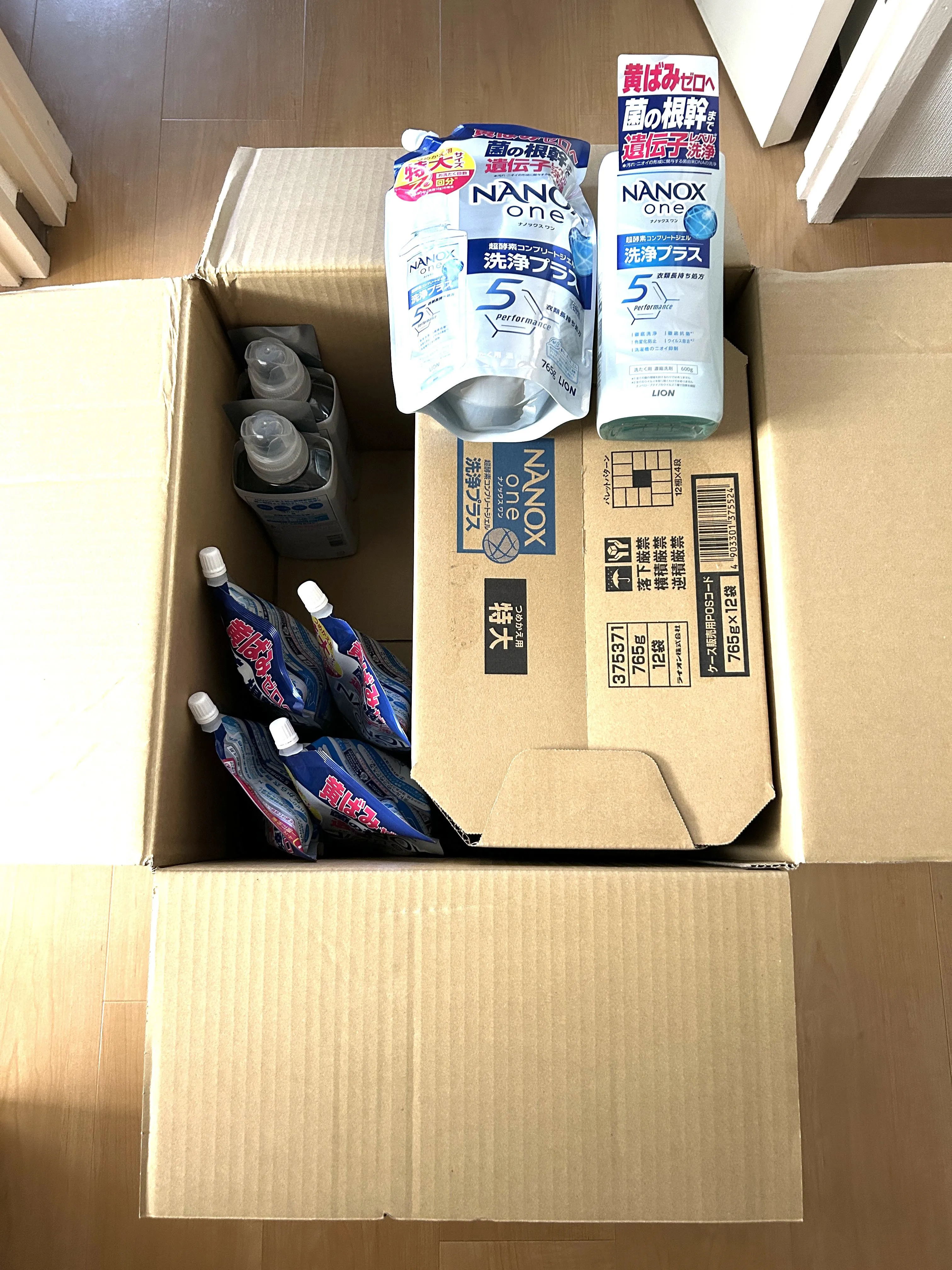 ふるさと納税で千葉県市原市から届いたNANOX one 洗浄プラスの段ボール箱と、本体ボトル・詰め替えパウチがぎっしり詰まった様子