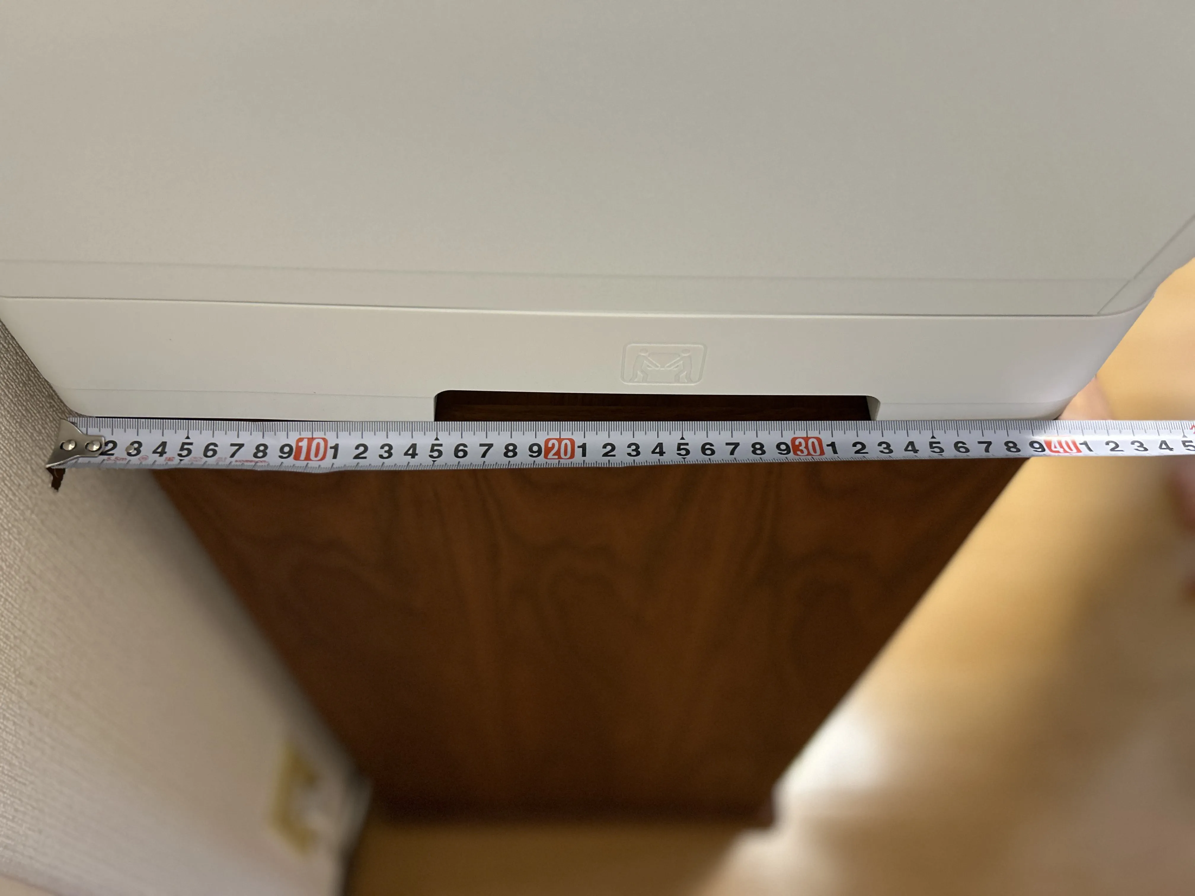 メジャーで本体の奥行きを測っている様子